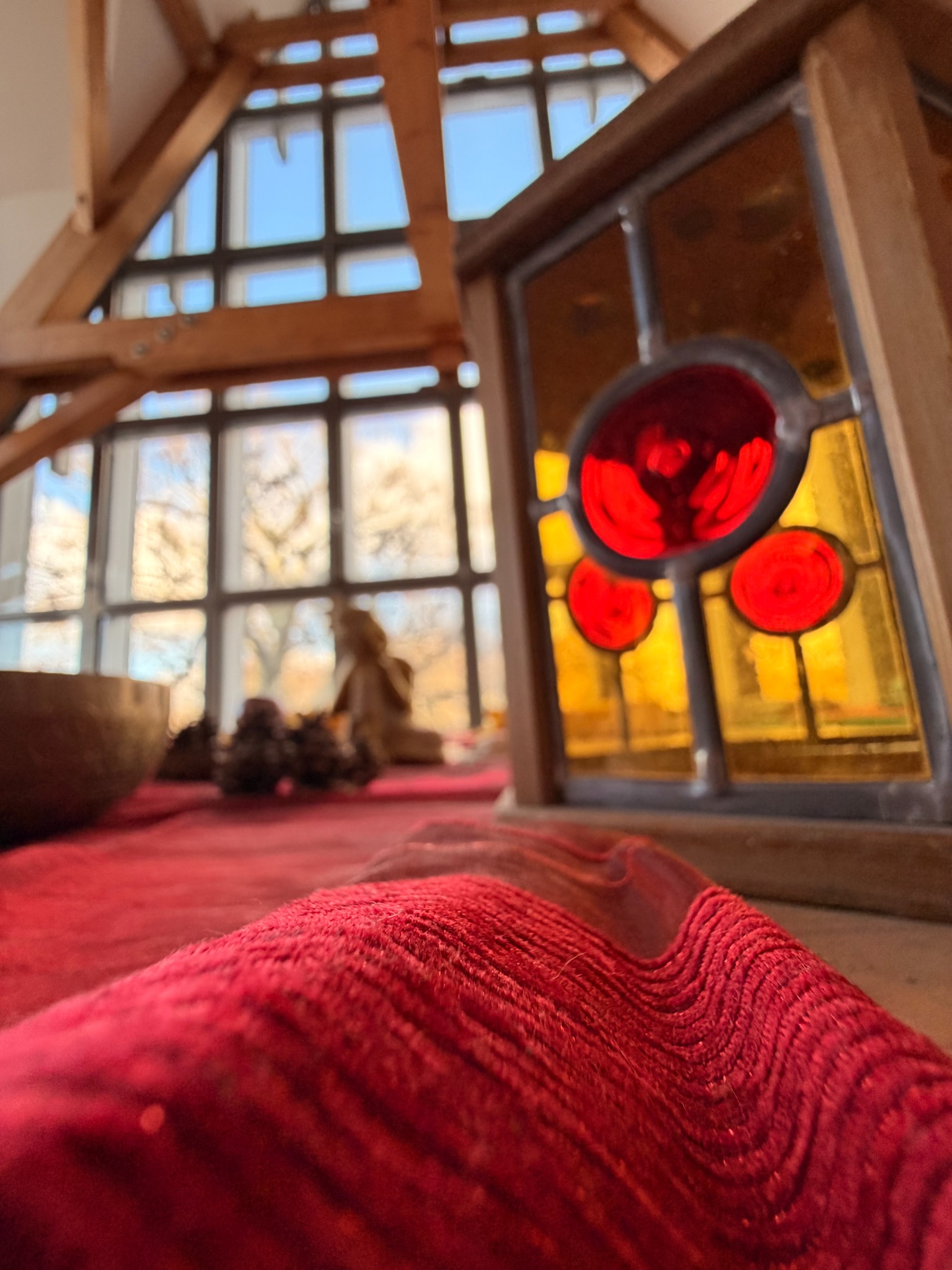 Das Atelier im Schloss Trebsen mit rotem Polster, Glasbild und offenem Dachgebälk